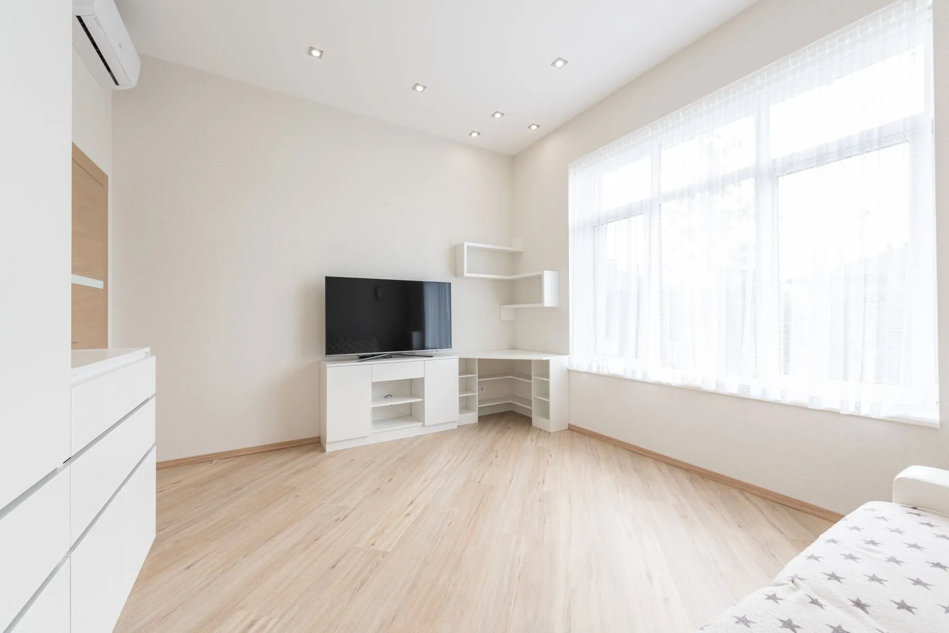 An empty, freshly cleaned flat with pale wood floors and large windows