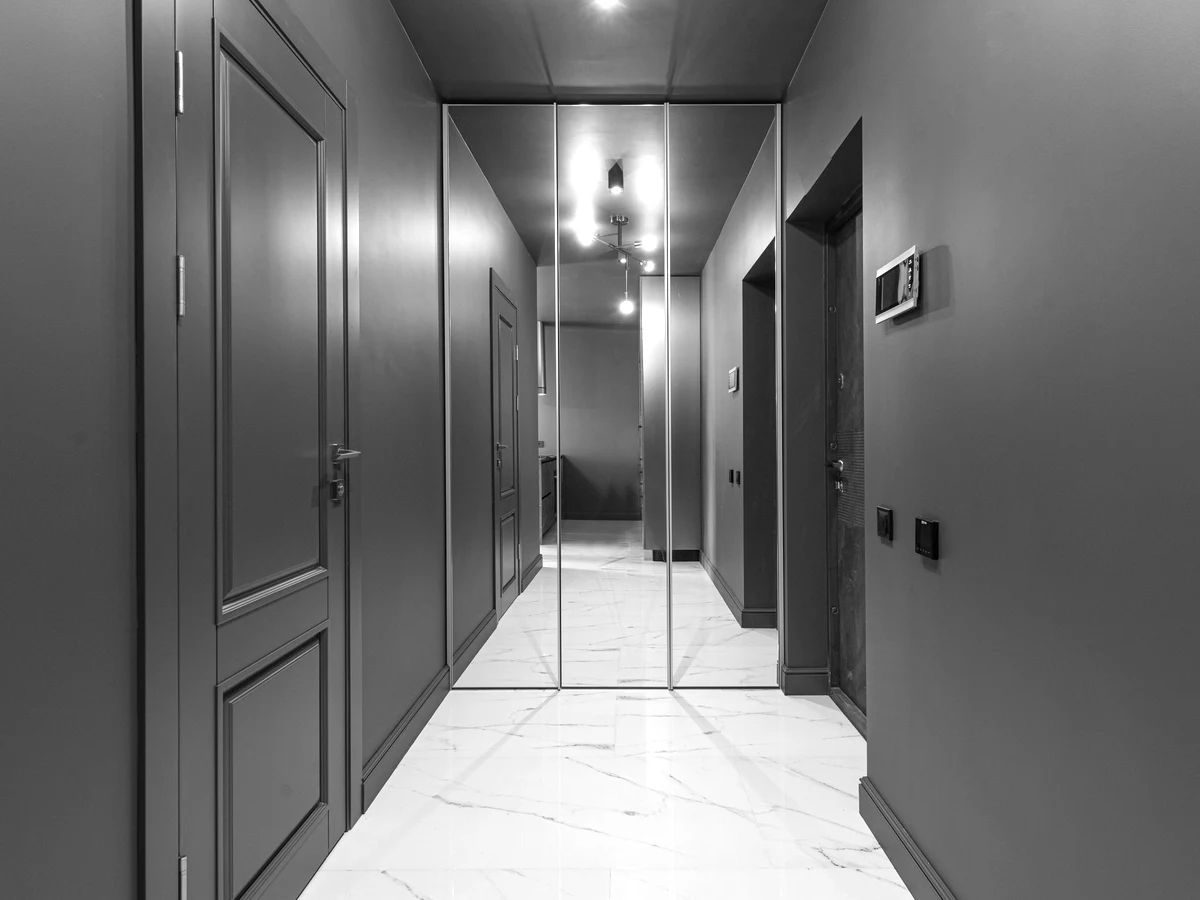 Polished hard floor down a narrow corridor, printed achromatic with the specular return at full.
